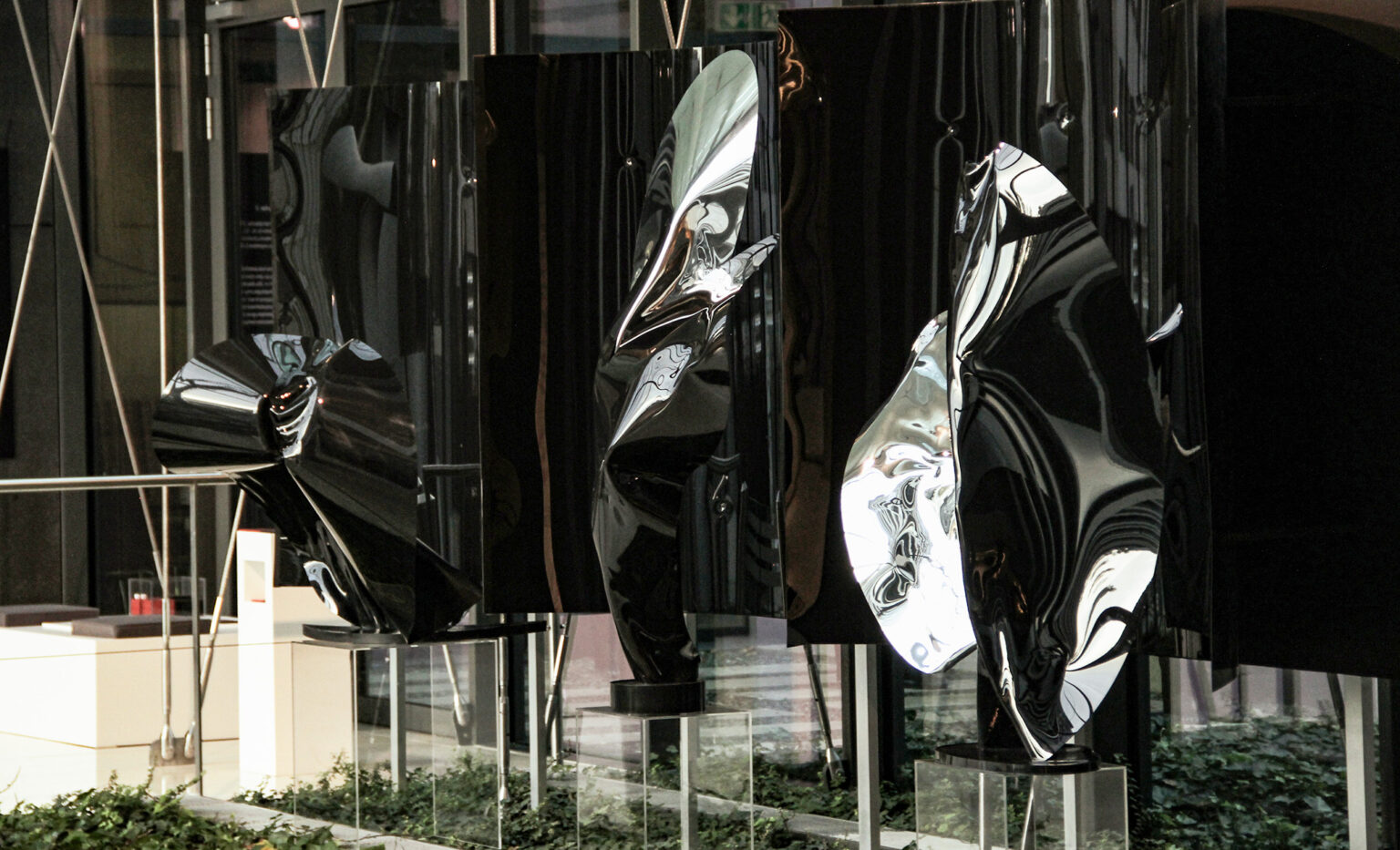 Widok wystawy, trzy, abstrakcyjne rzeźby na postumentach