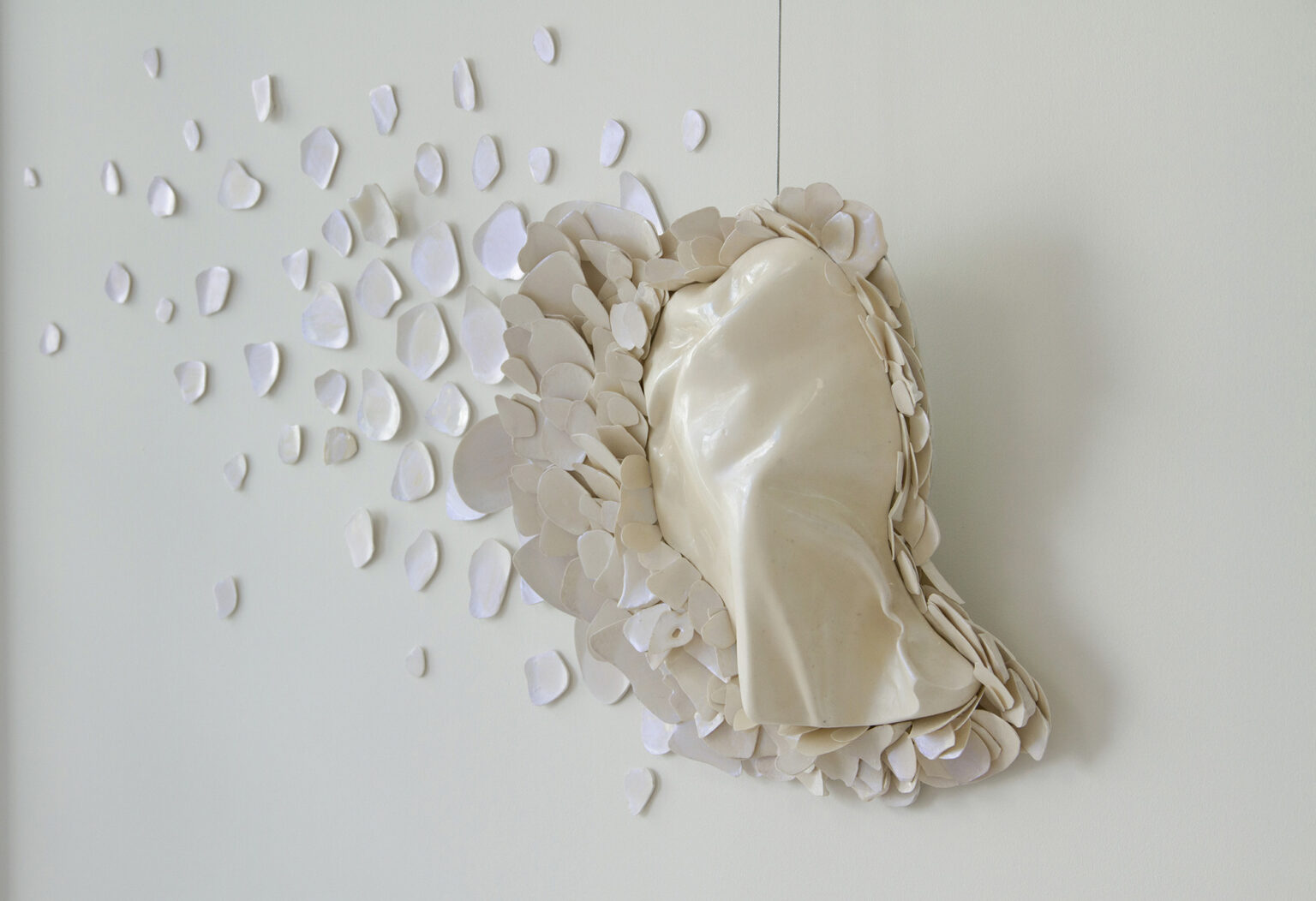 Rzeźba o abstrakcyjnym kształcie, wisząca na ścianie