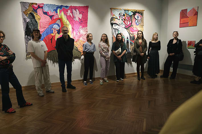 Autorzy stojący przy pracach, artystki i artyści w Muzeum w Kazimierzu Dolnym.