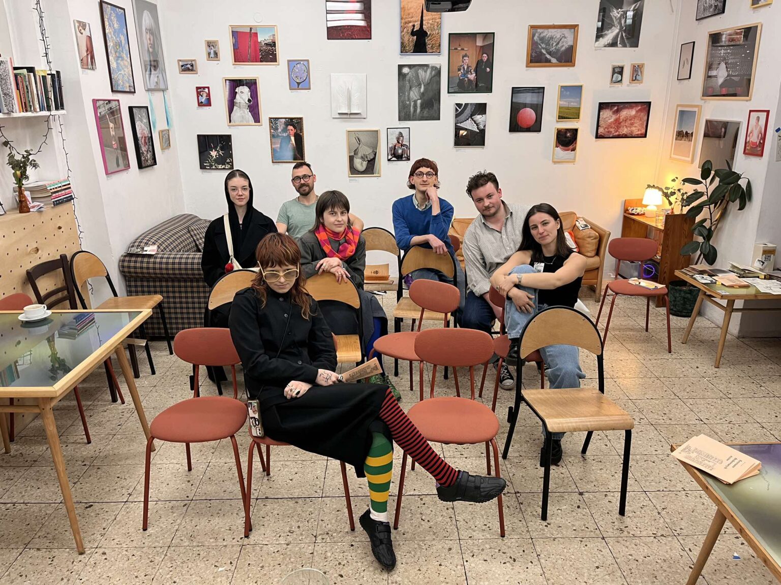 Grupa studentów z prowadzącym, 7 osób siedzących na krzesłach w sali