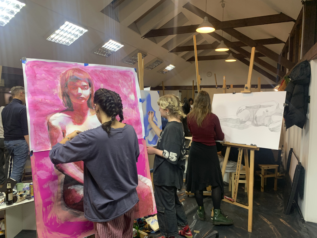 Studenci rysujący przy sztalugach na warsztatach