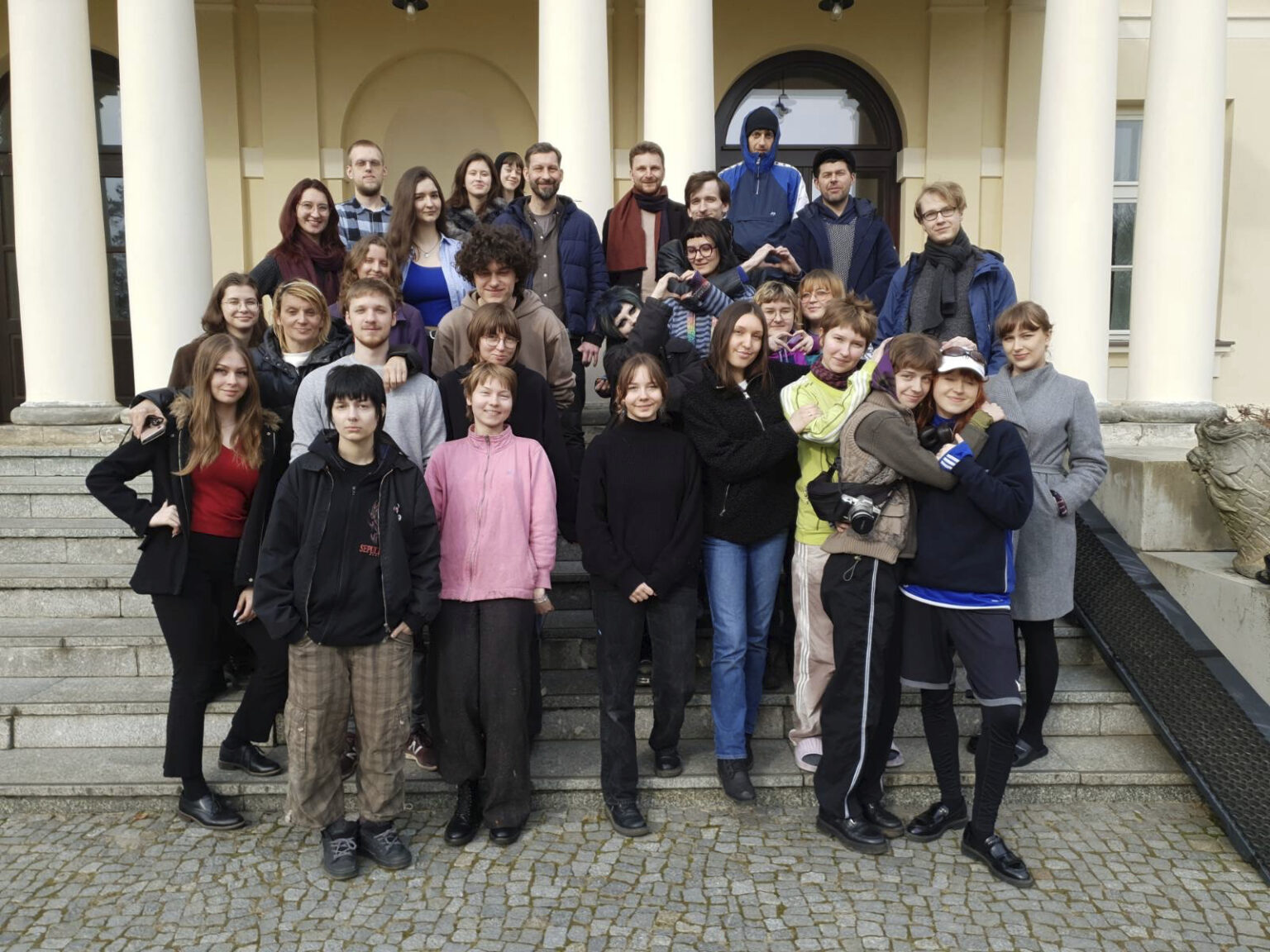 Grupa studentów z prowadzącymi na schodkach pałacu w Dłużewie