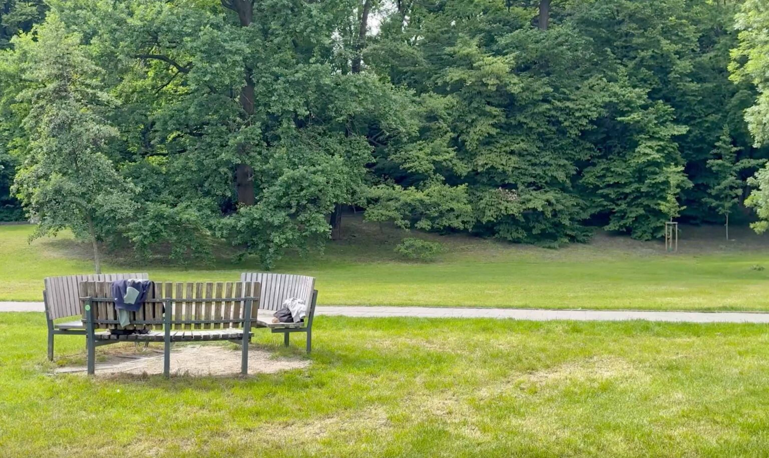 Klatka z filmu, widok pustej ławki w parku