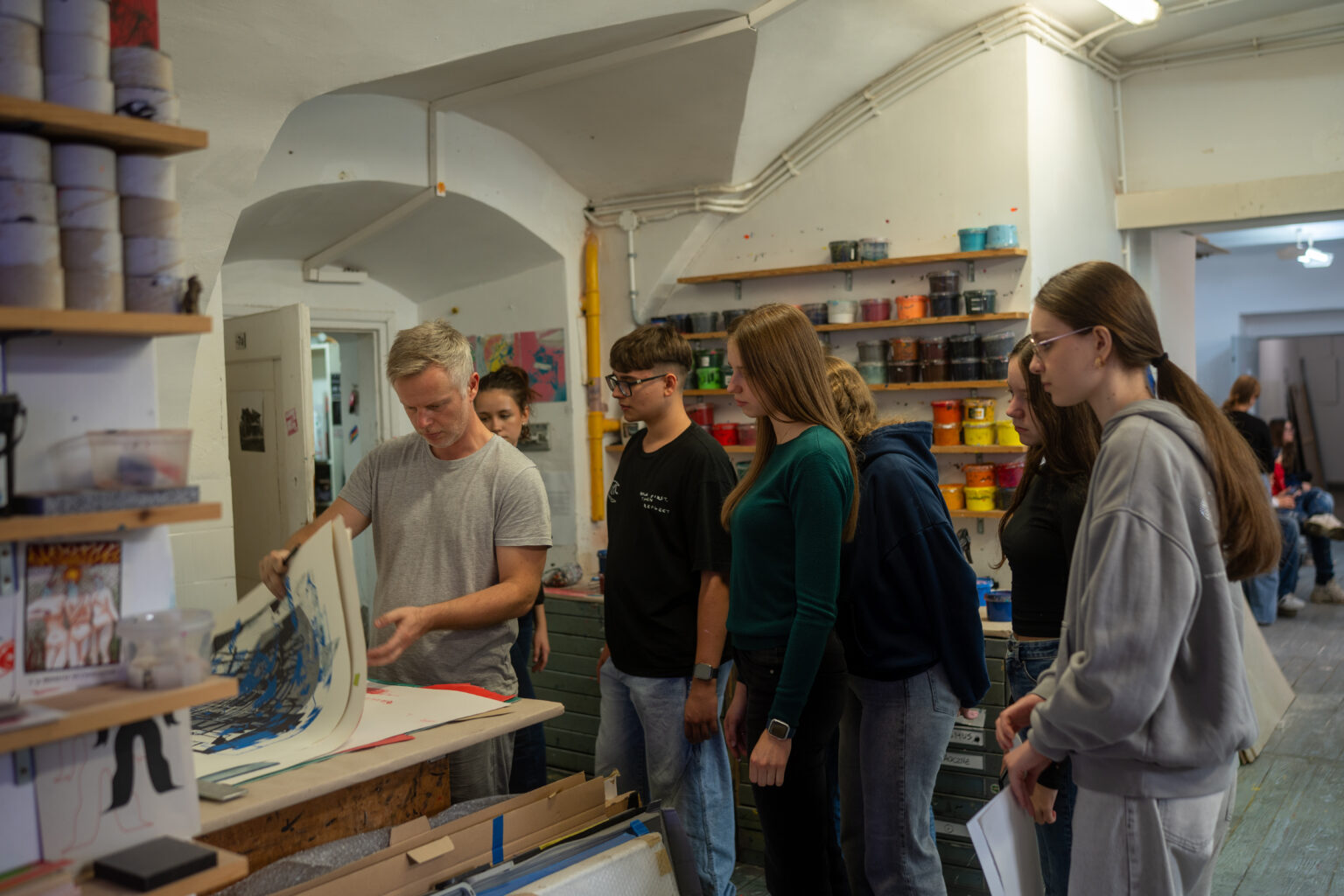 Grupa uczniów w trakcie pokazu wykonywania odbitki semigraficznej