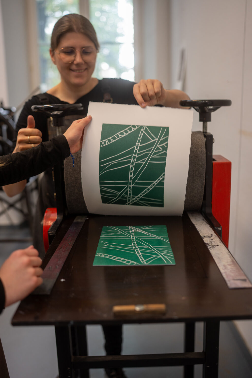 Prezentacja gotowej odbitki linorytniczej na prasie drukarskiej