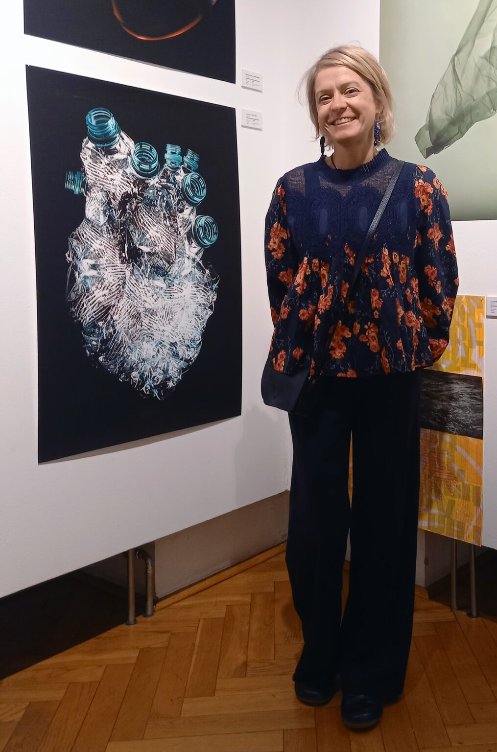 Artystka Anna Rendecka przy swojej grafice na wystawie.