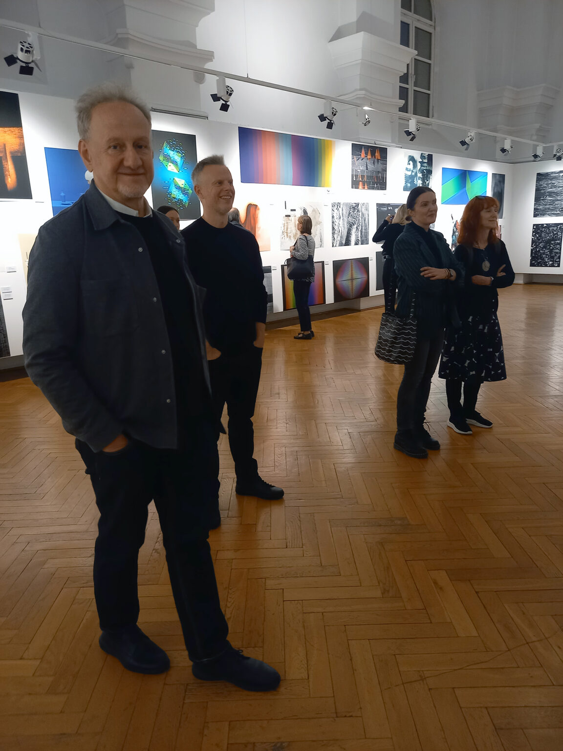 Artyści oglądający wystawę grafik cyfrowych.