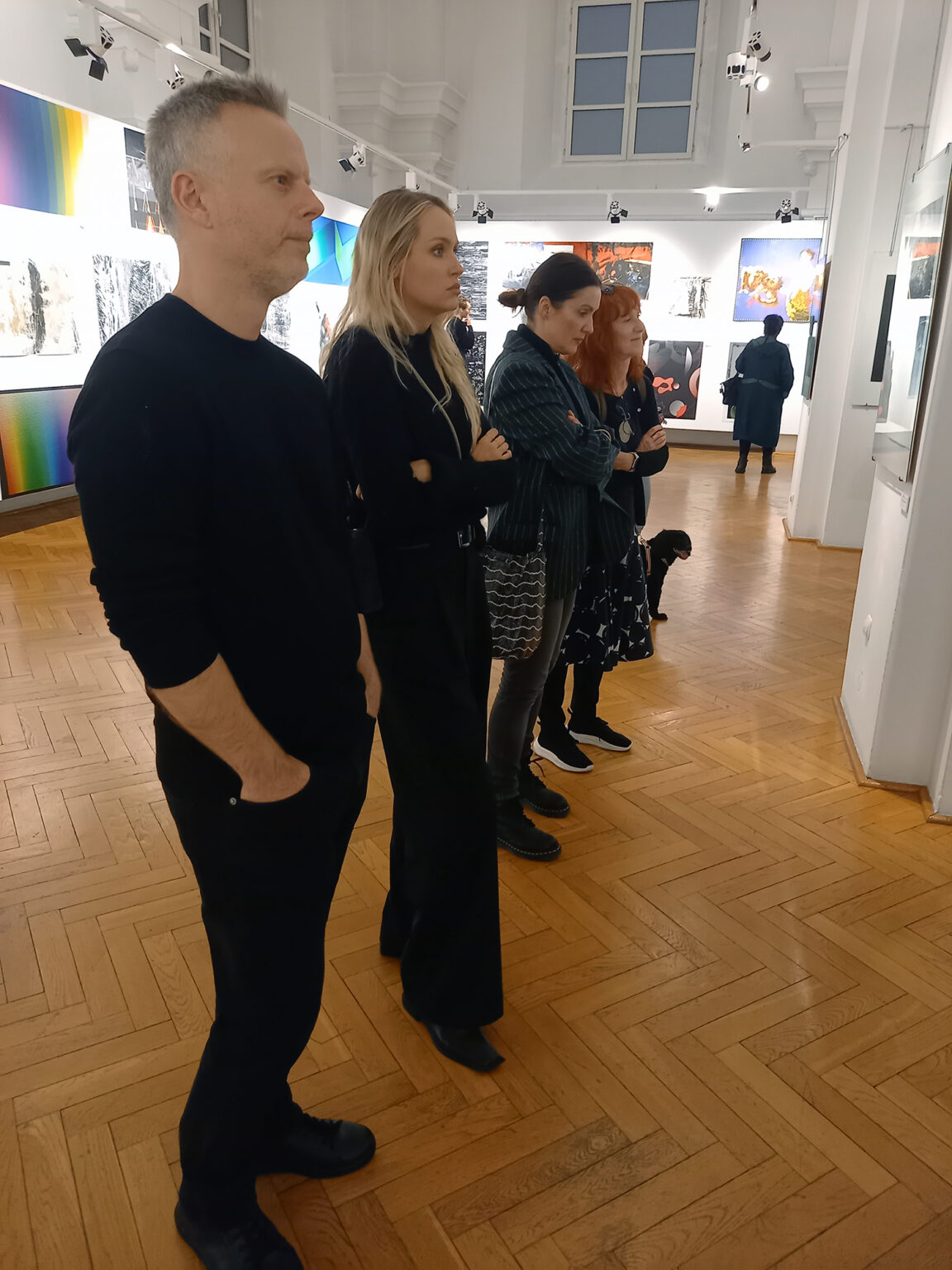 Artyści oglądający wystawę grafik cyfrowych.