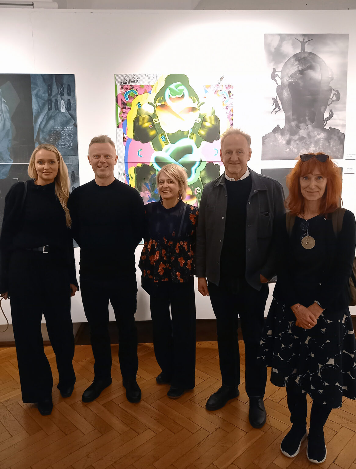 Zdjęcie grupy artystów na wystawie.