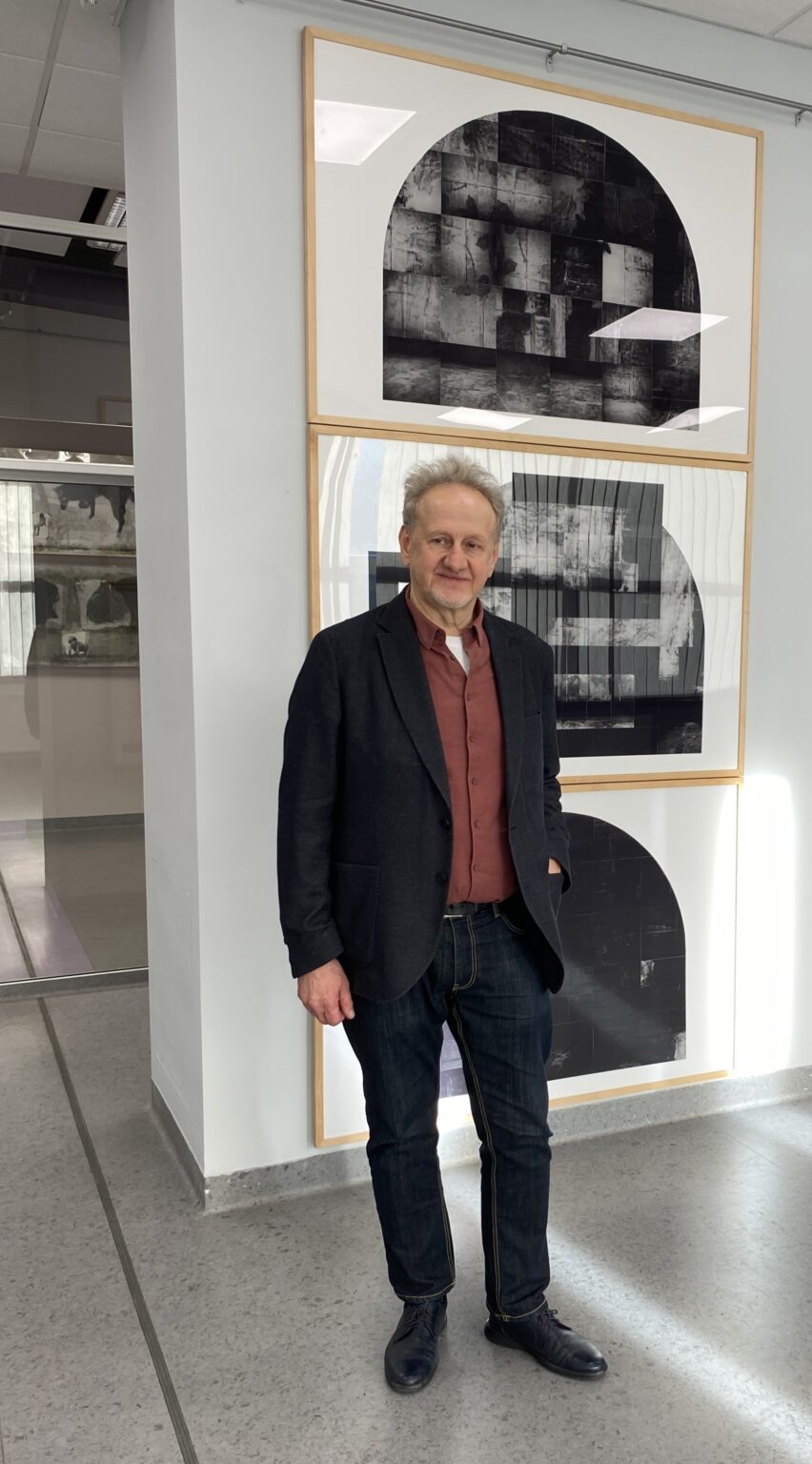 prof. Andrzej Węcławski na tle swoich prac graficznych