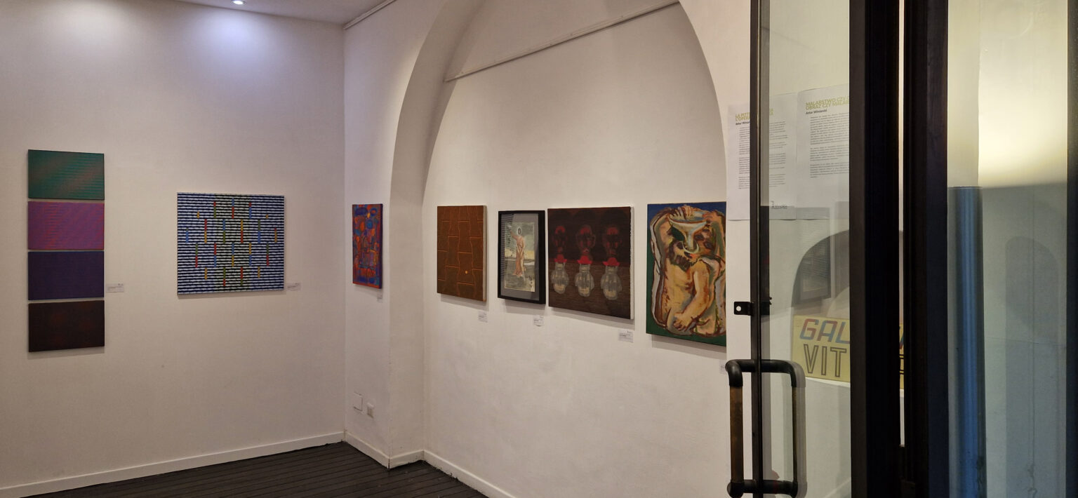 Widok wystawy malarstwa, wiszącej na białych ścianach galerii w Rzymie.