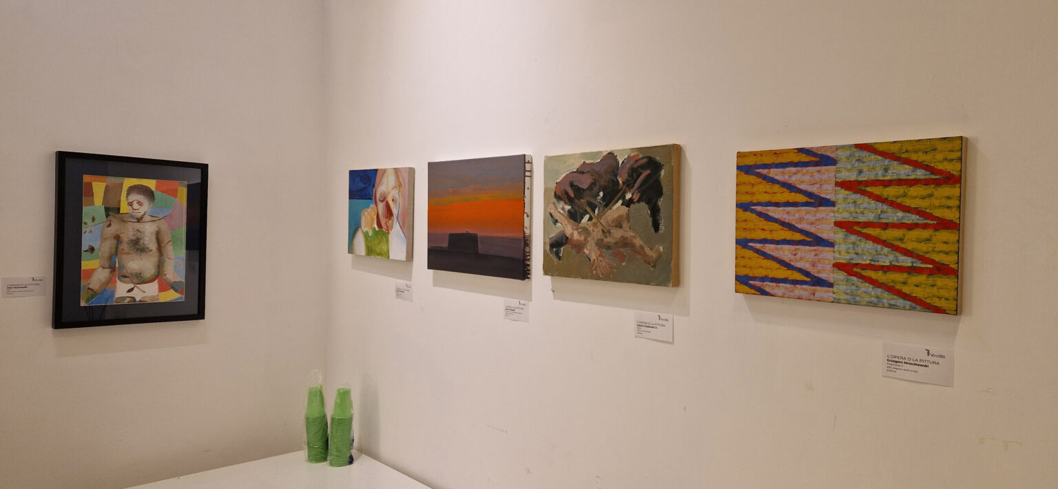 Widok wystawy malarstwa, wiszącej na białych ścianach galerii w Rzymie.