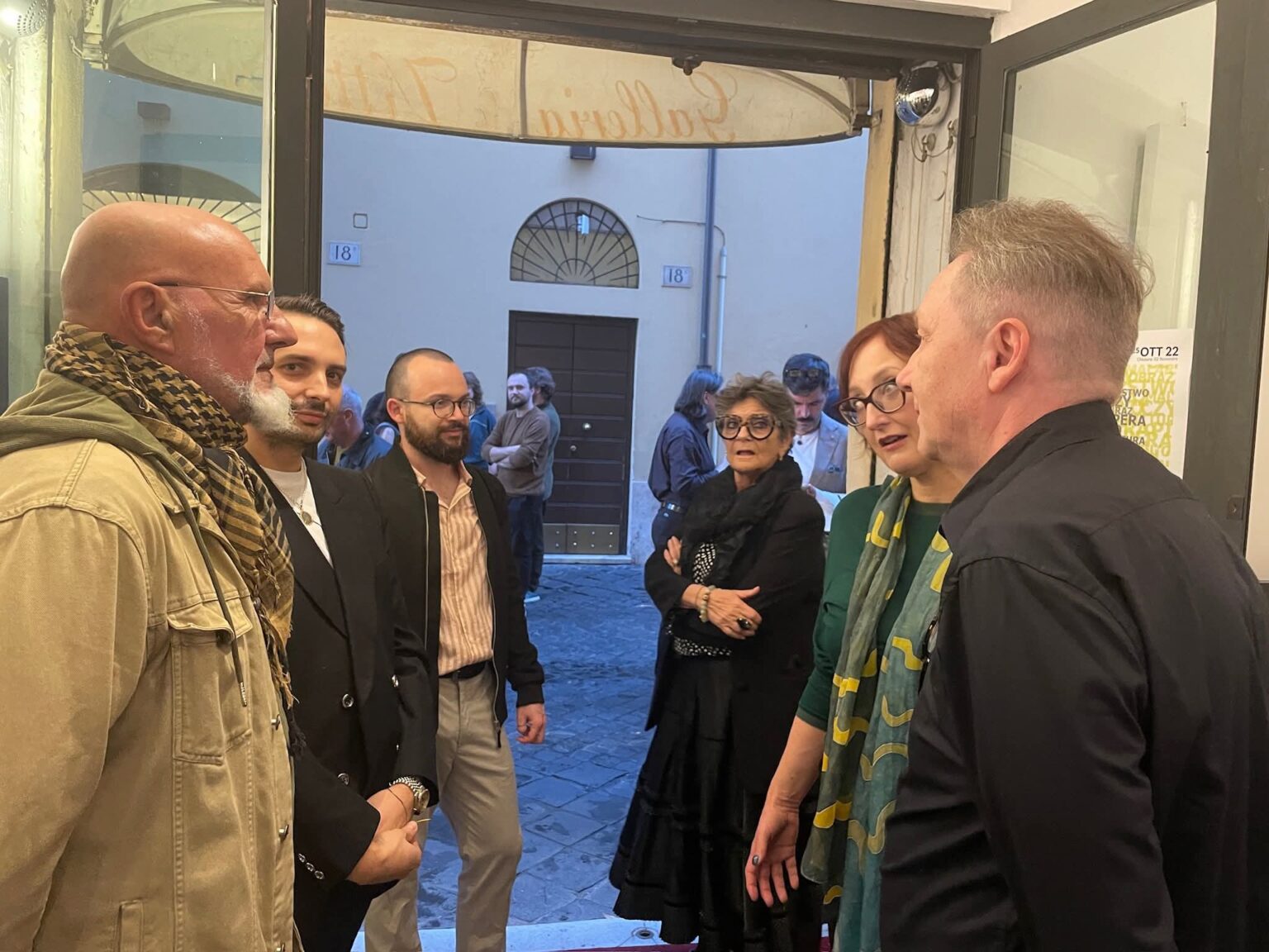 Grupa ludzi stojących w drzwiach galerii sztuki w Rzymie.