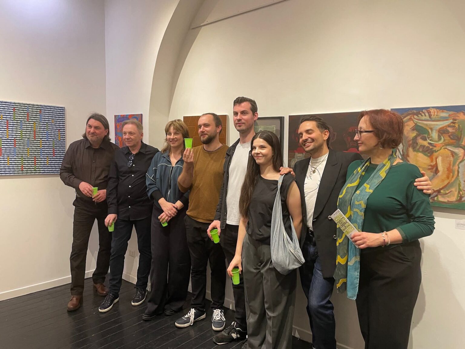 Artyści stojący na tle obrazów w galerii w Rzymie.