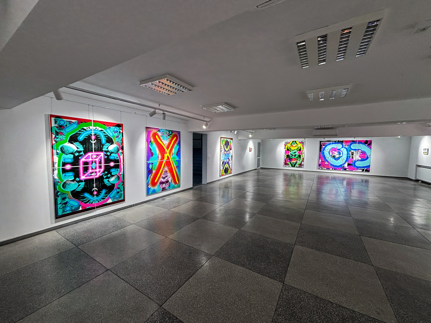 Widok wystawy 6 prac graficznych Kamila zaleskiego w sali z podłogą w szachownicę.