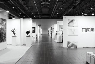 Widok stoisk z dziełami różnych artystów podczas Warszawskich Targów Sztuki