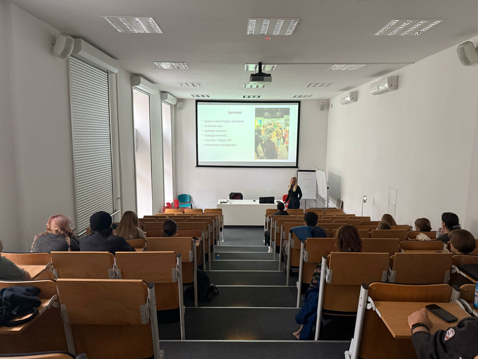 Widok sali wykładowej widzącej od góry z uczestnikami i prowadząca Katarzyną Marciniak.