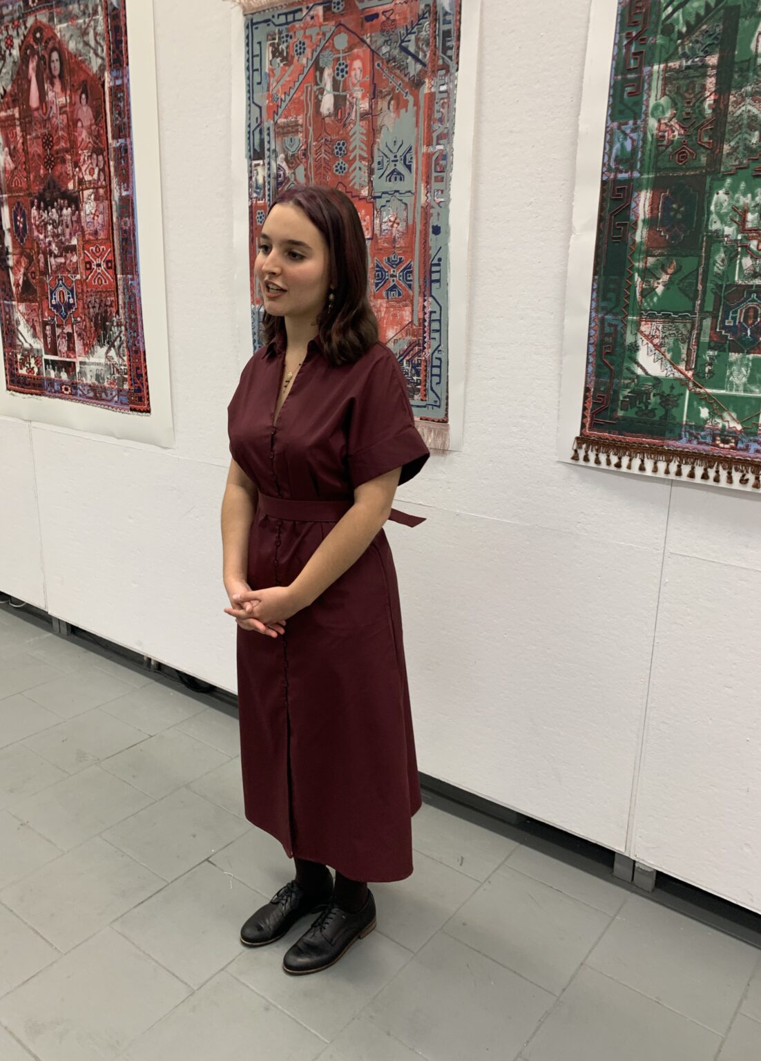 Artystka Maja Padusińska na tle swoich prac wiszących na ścianie