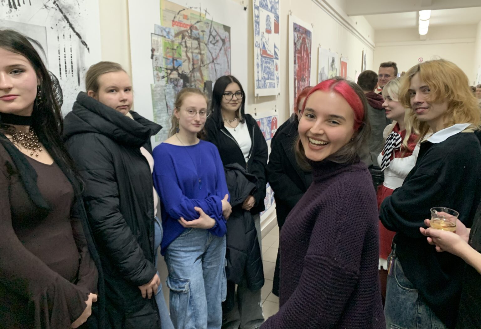 Otwarcie wystawy, grupa studentów na korytarzu akademickim.