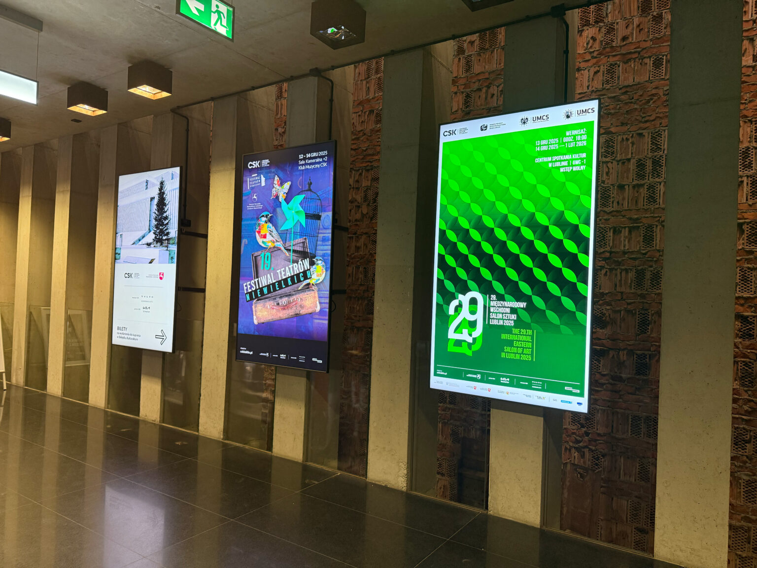 Multimedialne ekrany na wejściu do Centrum Spotkania Kultur, reklamujące wystawę.